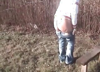 Chick with a tramp stamp tattoo shits in the field